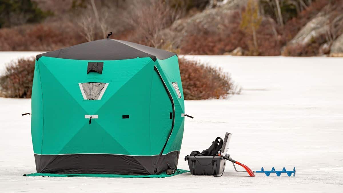 Ice fishing shelter and equipment on a frozen lake