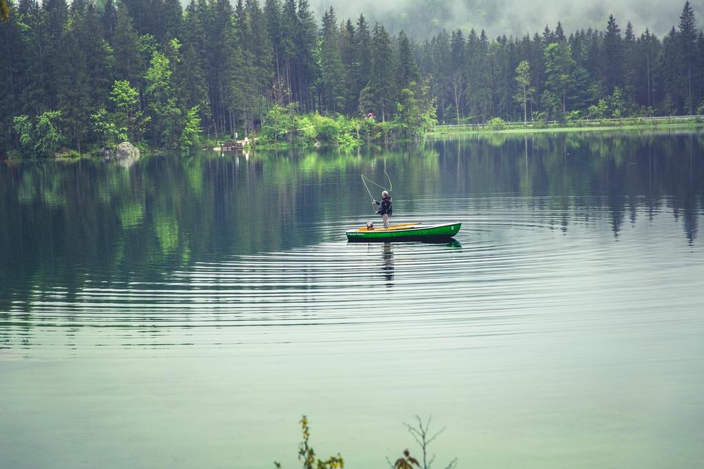 Man fly fishing for bream on a canoe.