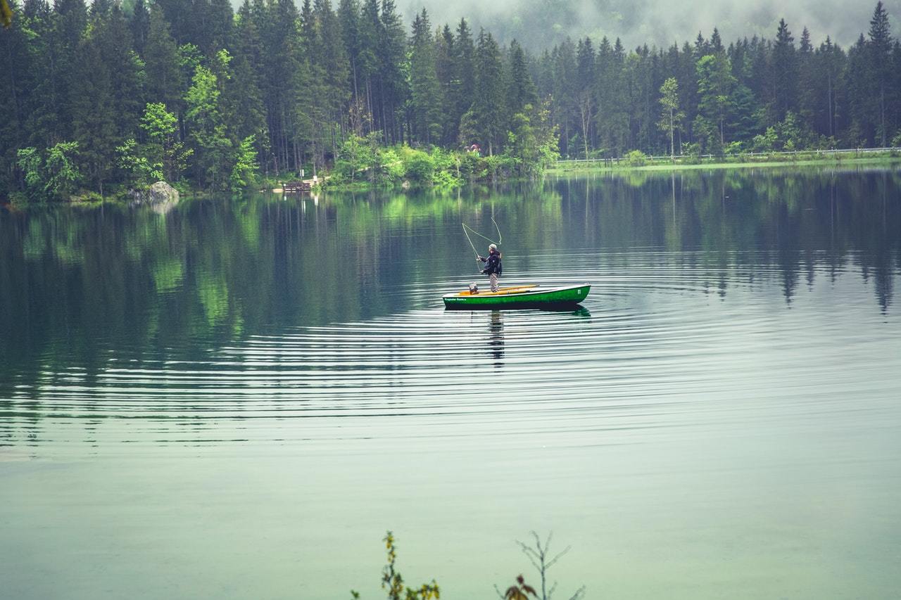 Man fly fishing for bream on a canoe.