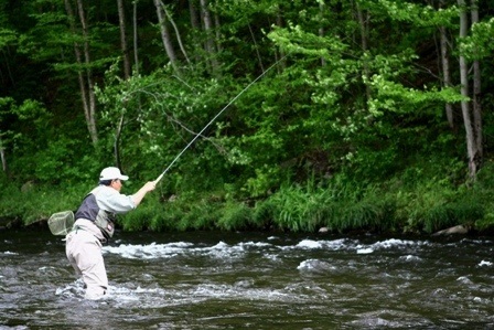 Man tenkara fly fishing in a stream.