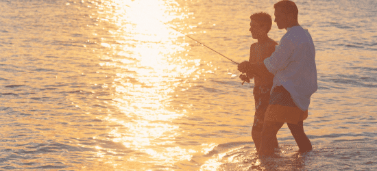 Two people fishing at dusk.