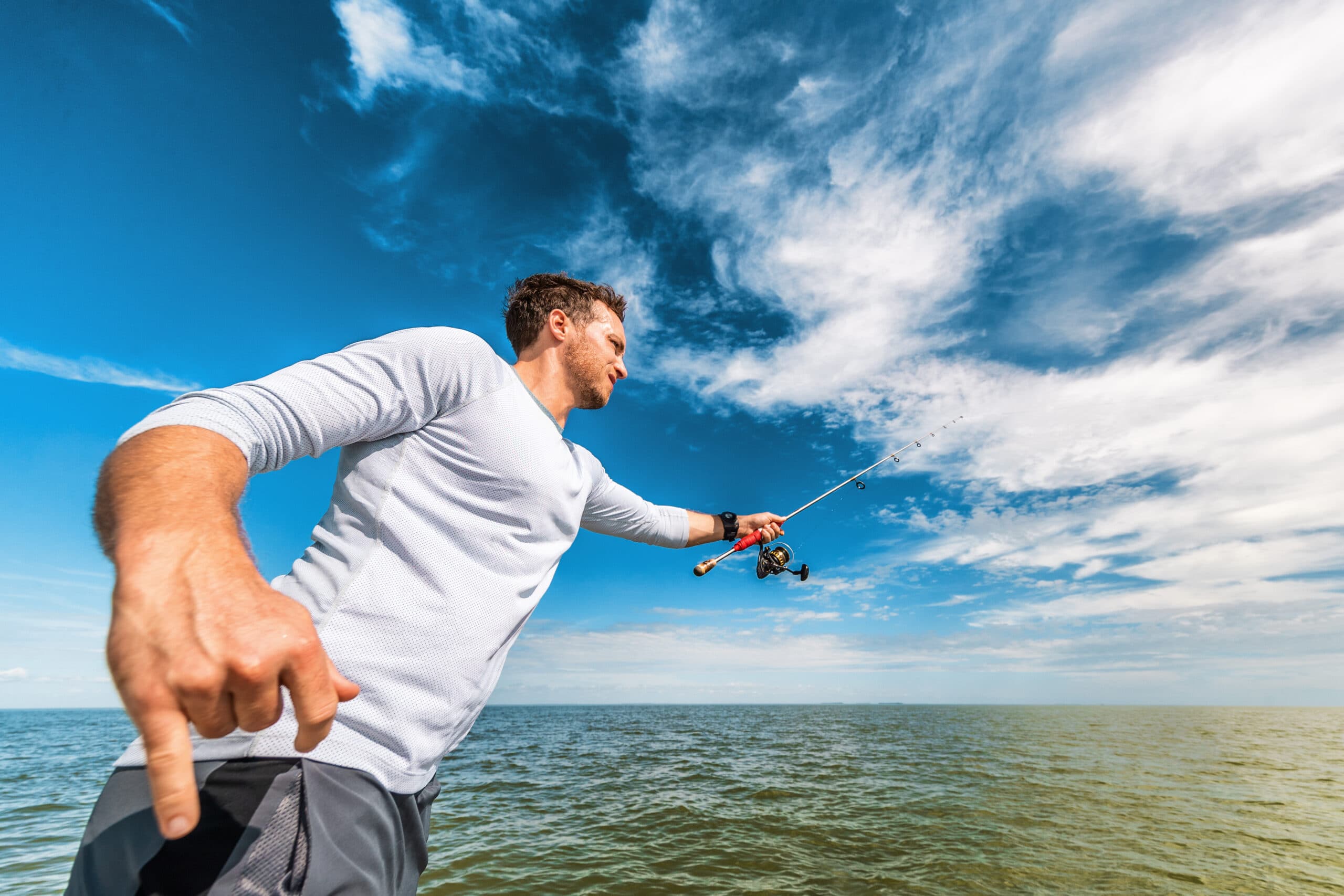 Fishing man in Florida boat excursion tour throwing line with road fisherman in Everglades