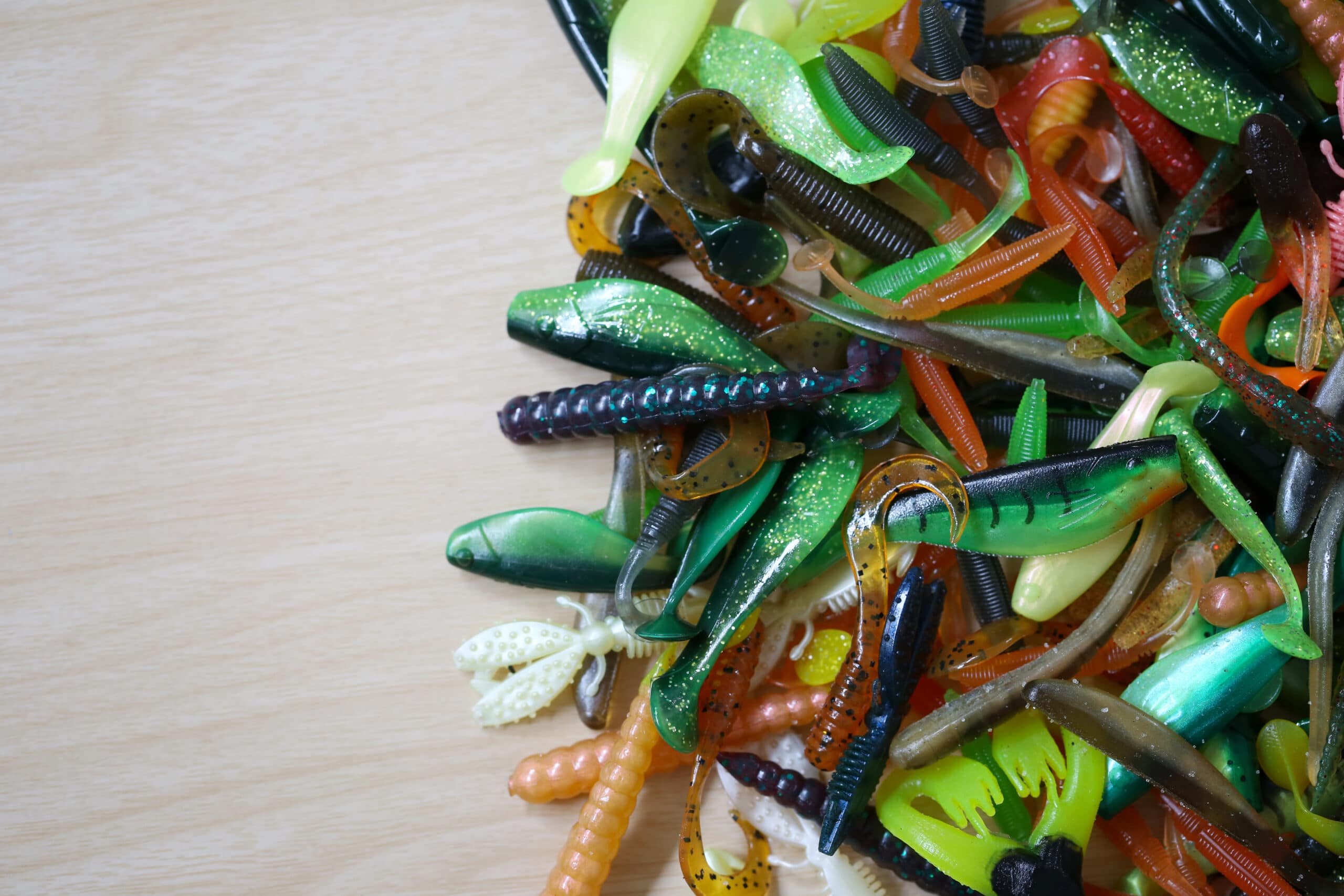 Pile of rubber Fishing bait on wooden background for design in your work concept.