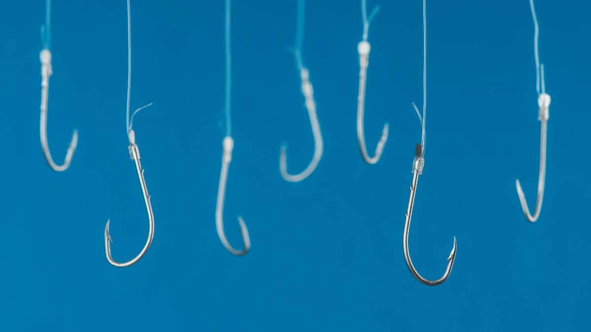 Fishing Hooks Dangling from fishing line on a light blue background